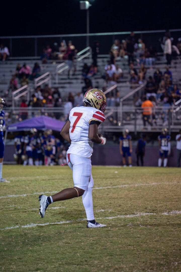 Football player runs with the ball on field.